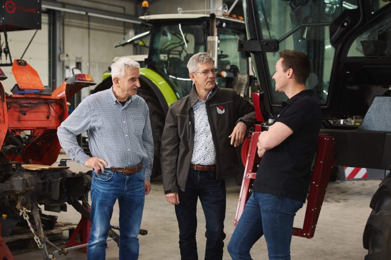 Drie mannen in gesprek in de werkplaats van Nouws Mechanisatie
