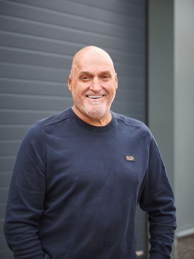 Portret van Ad Koremans, lachend voor de loods