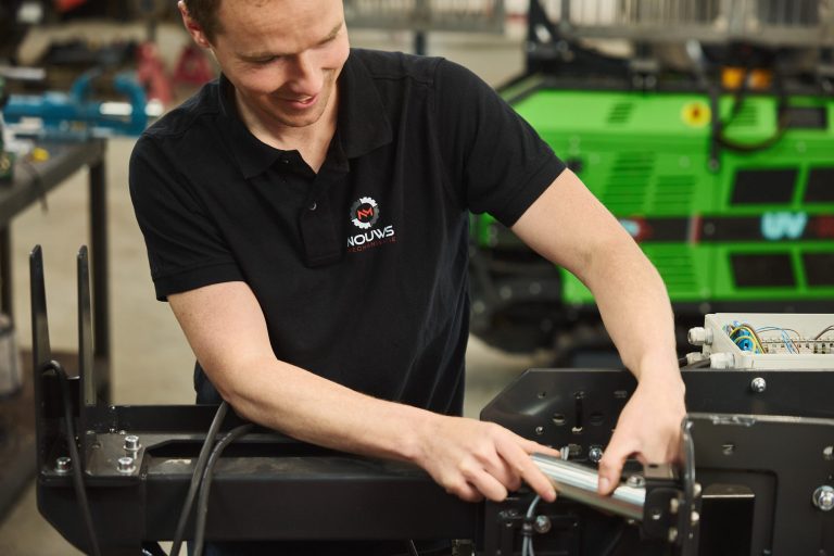 Een monteur van Nouws Mechanisatie aan het werk